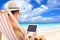 Relaxed man sitting on beach chairs and touching tablet