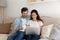 Relaxed millennial couple drink tea coffee watch movie using laptop