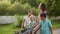 Relaxed mother walking with three children. Happy family relaxing in summer park