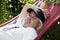 Relaxed old man lounging in a hammock. Tranquil moments for the old man in the hammock. Leisurely retreat for the old man in his