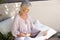 Relaxed older woman outside with laptop