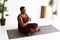 Relaxed overweight african american woman meditating at yoga studio