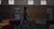 Relaxed pupil walking dark school hall alone. Teen schoolboy passing lockers.