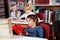 Relaxed Schoolboy Reading Book In Library