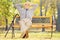 Relaxed senior gentleman sitting on a bench in a park