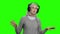 Relaxed senior woman in headphones on green screen.