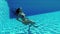 Relaxed serene young woman dives falling into pool depth