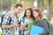 Relaxed students watching phone content outside