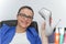 Relaxed and winning business woman sitting with her legs on desk and looking at her shoes