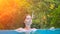 Relaxed woman in blue swimming pool. Girl in open swimming pool. Tropical jungle resort.