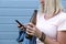 Relaxed woman with a bottle of beer, alcohol in hand and a smartphone, social problems and dependent behavior, weekend relaxation