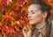 Relaxed woman holding leash in front of foliage