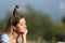 Relaxed woman meditating with an owlet on head