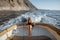 Relaxed woman sailing on the yacht near the rocky coast