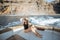 Relaxed woman sailing on the yacht near the rocky coast