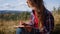 Relaxed woman sketching picture with pencil during hike in mountains