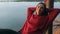 Relaxed woman smiling looking in camera lying in hammock near lake on nature.