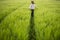 Relaxed woman standing in green field and enjoys calm nature