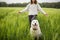 Relaxed woman standing in green field and enjoys calm nature