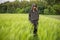 Relaxed woman standing in green field and enjoys calm nature