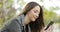 Relaxed woman using a smart phone in a park