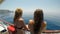 Relaxed young female tourists friends traveling on a sailboat looking the sea and summer sunny day -