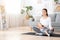 Relaxed Young Mother Meditating While Breastfeeding Her Baby At Home, Practicing Yoga