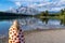 Relaxed young woman draped in a pumpkin blanket enjoys the view at Two Jack Lake in Banff National Park