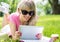 Relaxed young woman using tablet computer outdoors