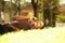 Relaxing african american man lying on grass in park while talking with mobile phone