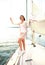 Relaxing attractive young woman on vacation standing on yacht.