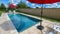 A relaxing backyard swimming pool with red umbrellas