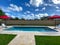 A relaxing backyard swimming pool with red umbrellas