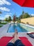 A relaxing backyard swimming pool with red umbrellas