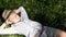 Relaxing boy under the green tree catching the warm sun rays shining through the leaves