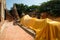 Relaxing Buddha statue at Ayutthaya ruined temple covered with a golden mantle