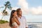 Relaxing casual couple watching sunset together on Waiohai beach, Poipu in Kauai, Hawaii. Beautiful multiracial couple