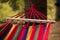 Relaxing lazy time with hammock in forest. Beautiful landscape with swinging hammock in summer garden, sunny day.