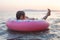 Relaxing little girl floating on inflatable ring on summer sea waves