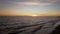 Relaxing orange and blue sky with beautiful horizon sea sunset with water`s edge and waves crashing sand with amazing twilight`s