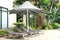 Relaxing rattan chairs with a big umbrella beside the swimming pool