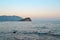 Relaxing seascape in Budva, Montenegro. Lonely island on horison under sunset sky. Time for travel, relax, leisure