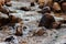 Relaxing stream flowing through stones during winter