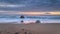 Relaxing Sunset on the beach with orange reflection in the sand and heavy clouds