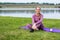 Relaxing after training. Mined and body relaxation in park. Woman on a yoga mat to relax outdoor. Young woman resting on mat after