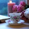 Relaxing by the window on a cold rainy day with books and cup of tea.