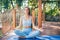 Relaxing woman with closed eyes sitting in a lotus position