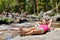 Relaxing woman hiker sleeping by river in nature