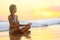 Relaxing - Yoga woman meditating at beach sunset