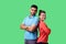 Reliable friendship. Cheerful young couple of friends in casual wear standing back to back. isolated on green background